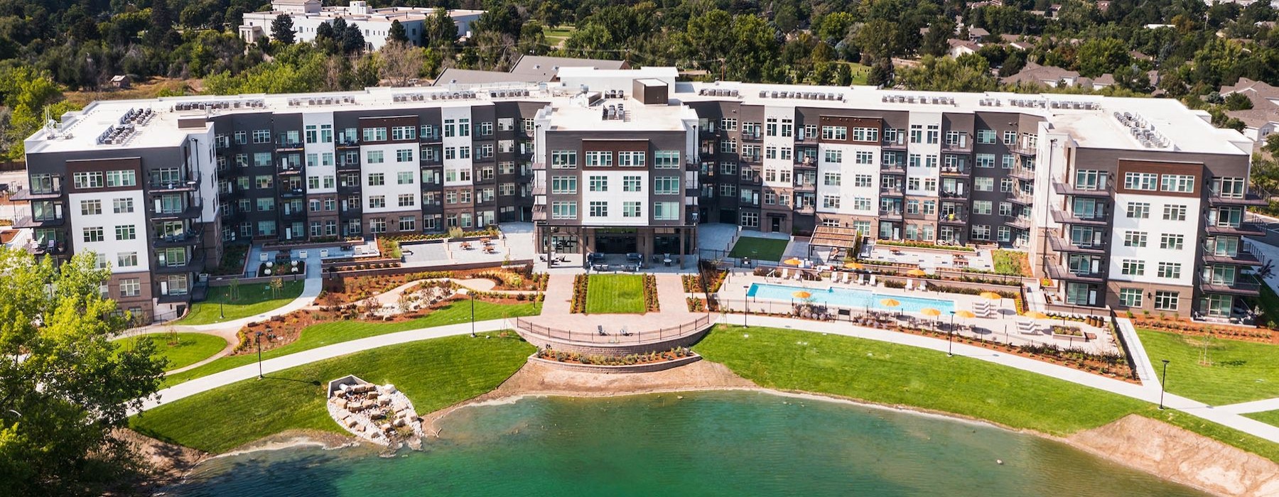 an aerial view of an apartment building with water in front