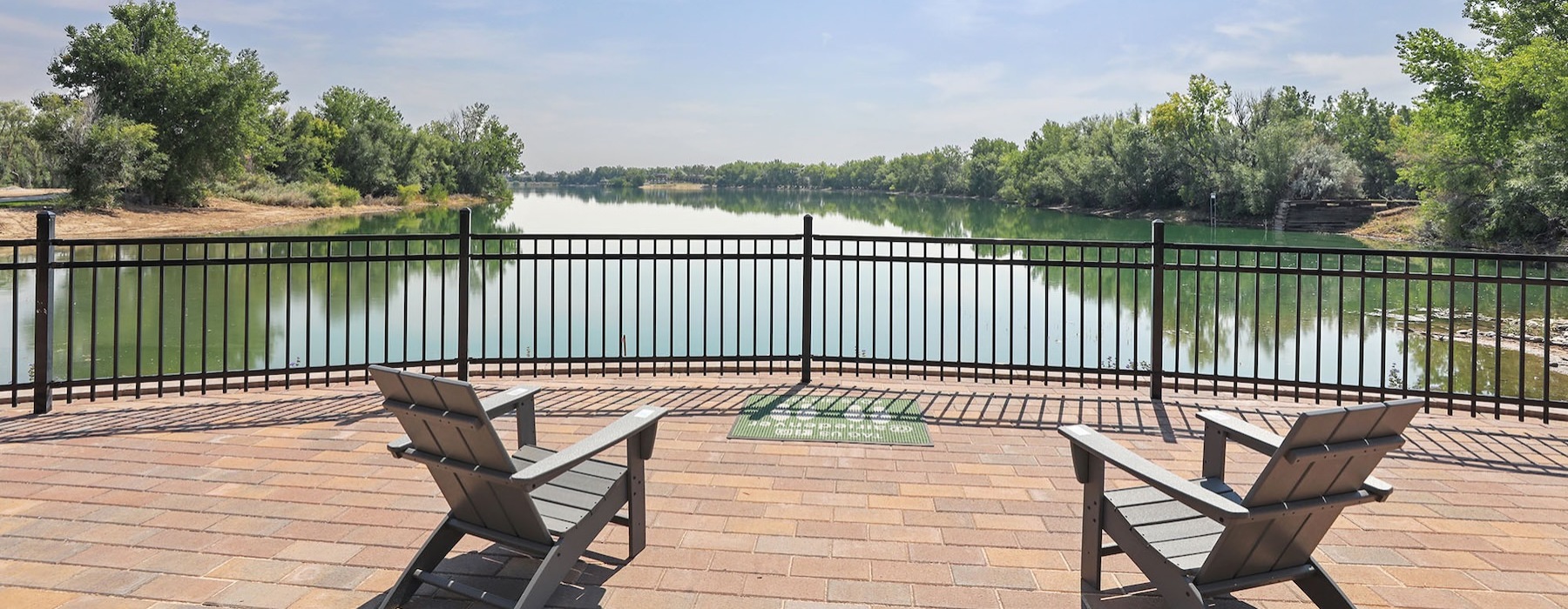 a patio with chairs looking at a body of water
