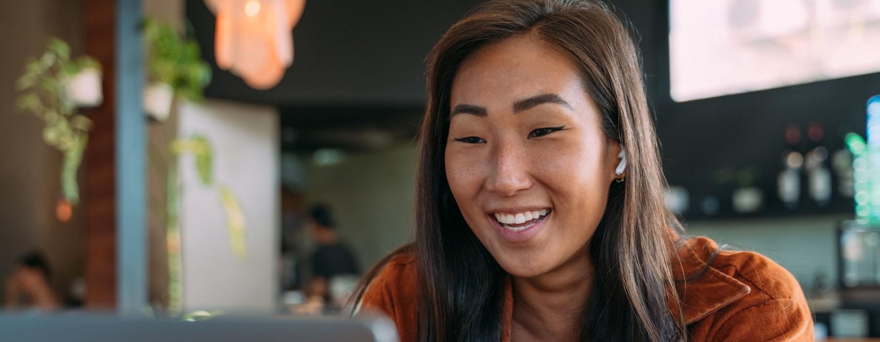 a woman smiling while working on laptop