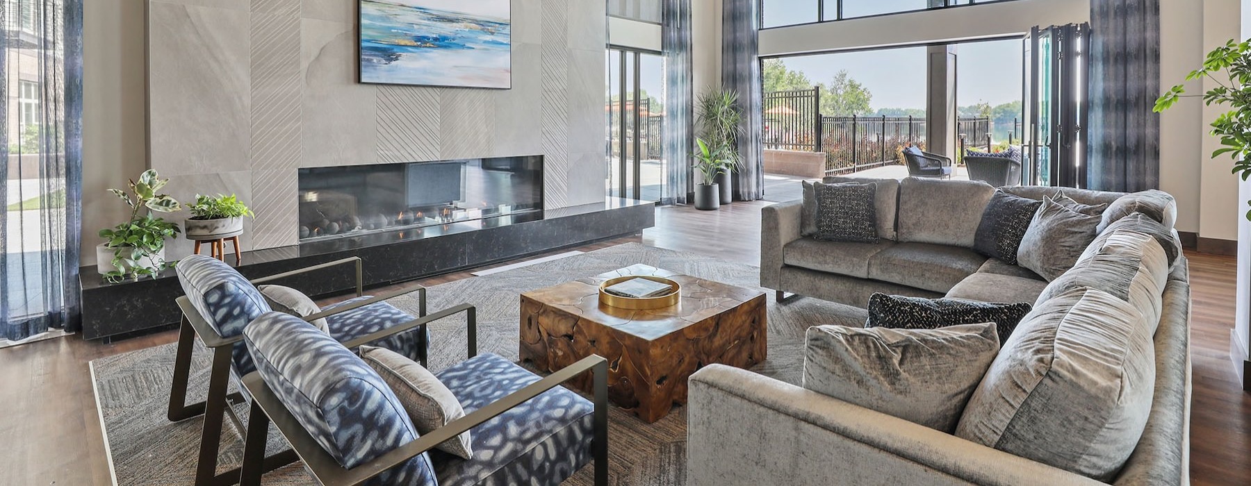 a clubroom with a couch, chairs and a fireplace