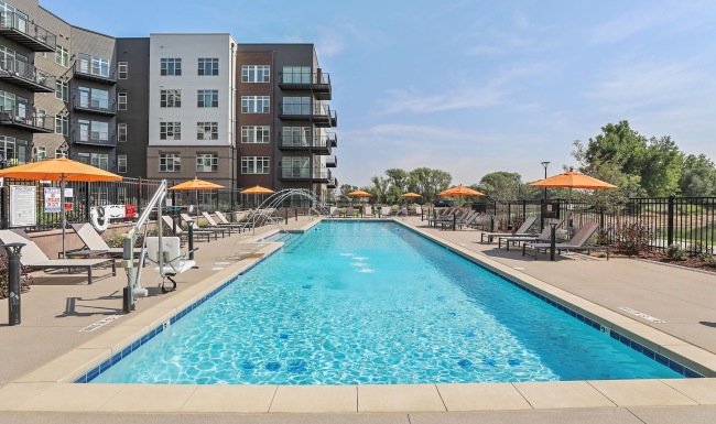 a swimming pool with chairs and umbrellas
